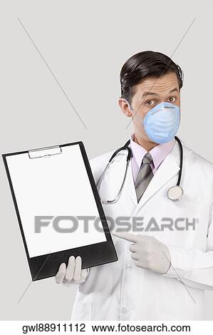 Stock Image - Doctor wearing a flu mask and showing a clip board. Fotosearch