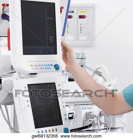 Stock Photograph - Doctor working on a cardiac monitor screen. Fotosearch