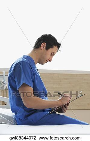 Doctor writing on a clipboard View Large Photo Image Stock Image - Doctor writing on a clipboard. Fotosearch