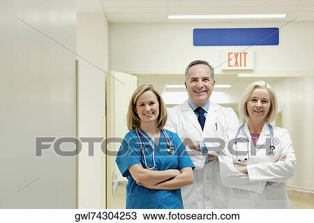 Doctors and a nurse smiling in a hospital View Large Photo Image Stock Image - Doctors and a nurse smiling in a hospital. Fotosearch