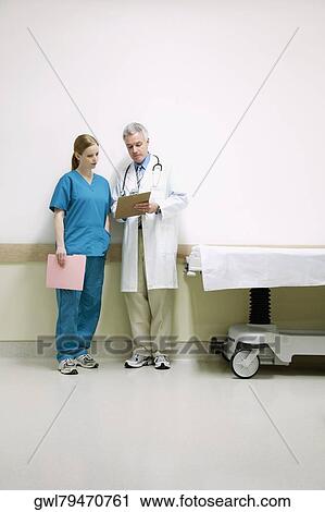 Doctors discussing a medical report with a nurse View Large Photo Image Stock Image - Doctors discussing a medical report with a nurse. Fotosearch
