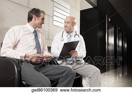 Doctors discussing a medical report View Large Photo Image Stock Photo - Doctors discussing a medical report. Fotosearch