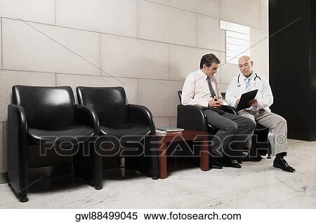 Doctors discussing a medical report View Large Photo Image Stock Photography - Doctors discussing a medical report. Fotosearch