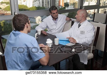 Doctors discussing in a cafeteria View Large Photo Image Stock Photo - Doctors discussing in a cafeteria. Fotosearch