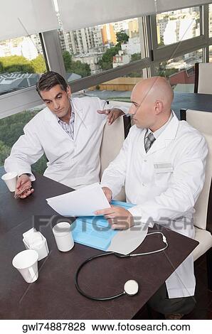 Stock Photo - Doctors discussing in a cafeteria. Fotosearch