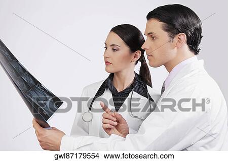 Doctors examining an x-ray report View Large Photo Image Picture - Doctors examining an x-ray report. Fotosearch