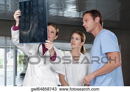Doctors examining an X-Ray report View Large Photo Image Stock Image - Doctors examining an X-Ray report. Fotosearch
