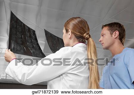 Doctors examining an X-Ray report View Large Photo Image Stock Photo - Doctors examining an X-Ray report. Fotosearch