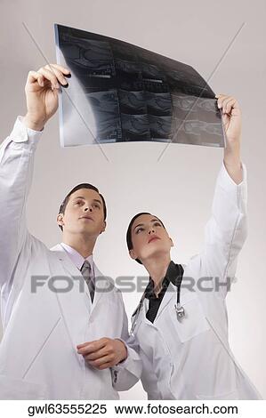 Doctors examining an x-ray report View Large Photo Image Stock Photography - Doctors examining an x-ray report. Fotosearch