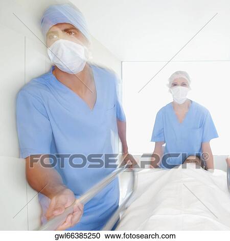 Doctors pushing a patient on a hospital Gurney in a hospital corridor View Large Photo Image Stock Image - Doctors pushing a patient on a hospital Gurney in a hospital corridor. Fotosearch