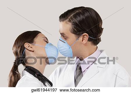 Doctors wearing flu masks and romancing View Large Photo Image Stock Photo - Doctors wearing flu masks and romancing. Fotosearch