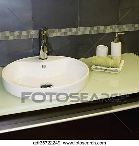 Stock Photo - Faucet with toiletries in the bathroom. Fotosearch