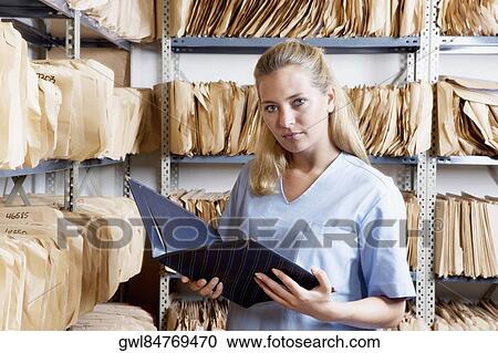Female doctor reading a file View Large Photo Image Stock Image - Female doctor reading a file. Fotosearch