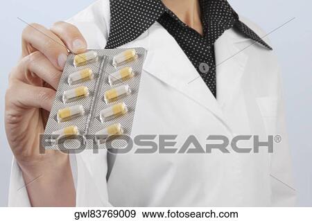 Female doctor showing a blister pack of capsules View Large Photo Image Stock Photo - Female doctor showing a blister pack of capsules. Fotosearch