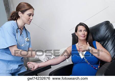 Female doctor taking blood sample of a pregnant woman View Large Photo Image Stock Photograph - Female doctor taking blood sample of a pregnant woman. Fotosearch