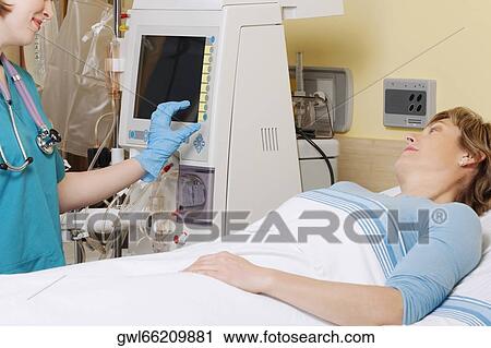 Female doctor working on a cardiac monitor View Large Photo Image Stock Image - Female doctor working on a cardiac monitor. Fotosearch