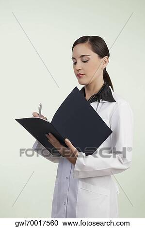 Female doctor writing in a file View Large Photo Image Stock Image - Female doctor writing in a file. Fotosearch