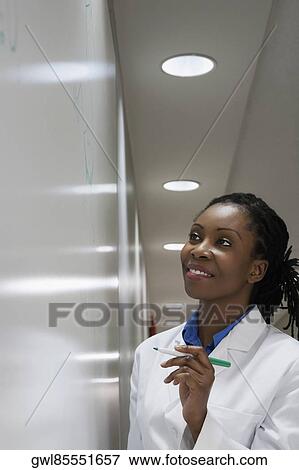Female doctor writing on a whiteboard in a hospital View Large Photo Image Stock Photo - Female doctor writing on a whiteboard in a hospital. Fotosearch