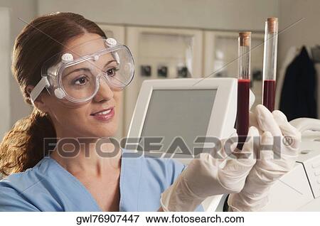 Female lab technician analyzing a blood sample in a test tube View Large Photo Image Stock Photo - Female lab technician analyzing a blood sample in a test tube. Fotosearch