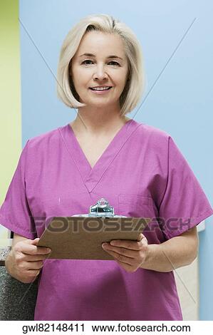 Stock Image - Female nurse holding a clipboard. Fotosearch