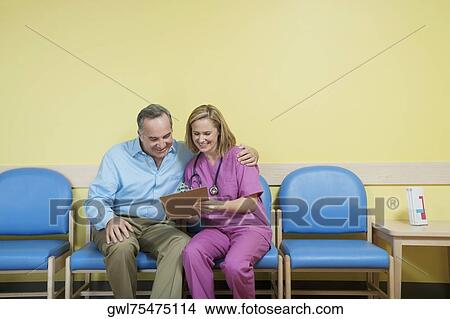 Female nurse showing a medical report to a patient View Large Photo Image Picture - Female nurse showing a medical report to a patient. Fotosearch