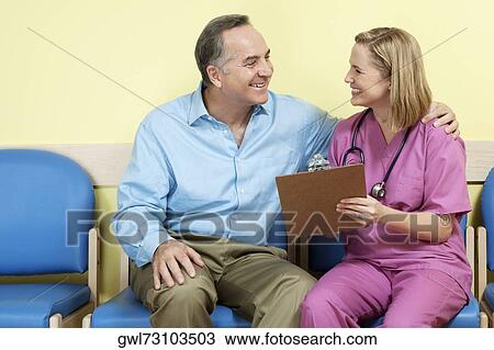 Stock Image - Female nurse showing a medical report to a patient. Fotosearch