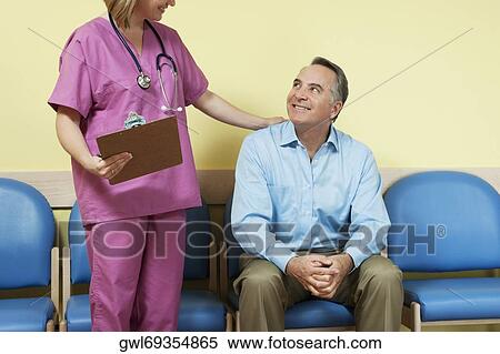 Stock Photography - Female nurse talking to a patient in the waiting room. Fotosearch