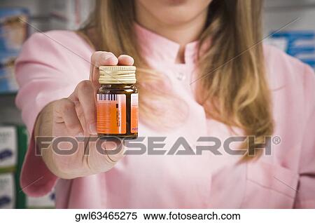 Female pharmacist holding a medicine bottle View Large Photo Image Stock Photography - Female pharmacist holding a medicine bottle. Fotosearch