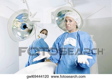 Stock Image - Female surgeon gesturing in an operating room. Fotosearch