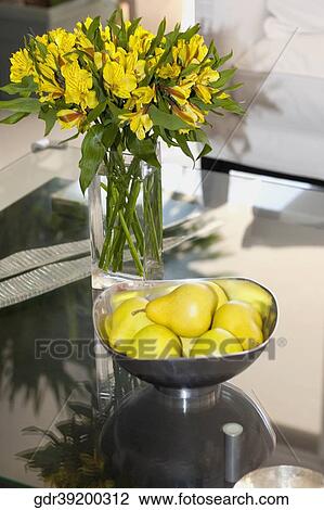Flower vase and a bowl of artificial pears on a table View Large Photo Image Stock Image - Flower vase and a bowl of artificial pears on a table. Fotosearch