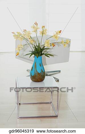 Flower vase with an armchair in a living room View Large Photo Image Stock Photo - Flower vase with an armchair in a living room. Fotosearch