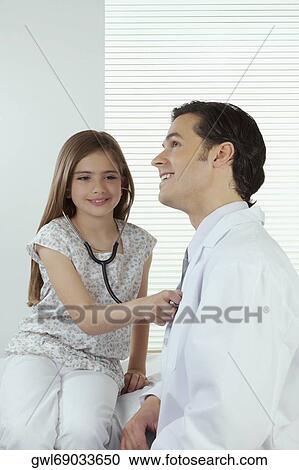 Girl listening to the heartbeat of a doctor with a stethoscope View Large Photo Image Stock Image - Girl listening to the heartbeat of a doctor with a stethoscope. Fotosearch