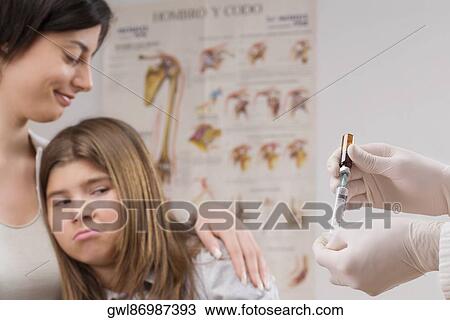 Girl looking at a doctor filling injection View Large Photo Image Stock Image - Girl looking at a doctor filling injection. Fotosearch