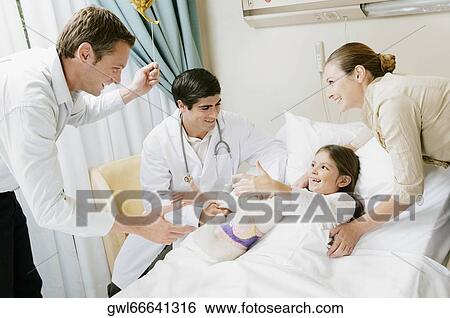 Girl on a hospital bed and her parents discussing with a doctor View Large Photo Image Stock Photograph - Girl on a hospital bed and her parents discussing with a doctor. Fotosearch