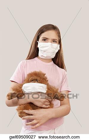 Girl wearing flu mask and holding a teddy bear View Large Photo Image Stock Photo - Girl wearing flu mask and holding a teddy bear. Fotosearch