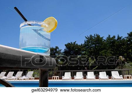 Glass of lemonade at the poolside View Large Photo Image Stock Photo - Glass of lemonade at the poolside. Fotosearch