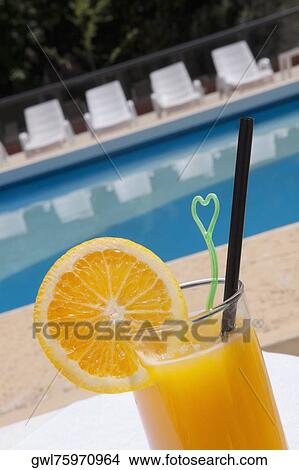 Glass of orange juice at the poolside View Large Photo Image Picture - Glass of orange juice at the poolside. Fotosearch