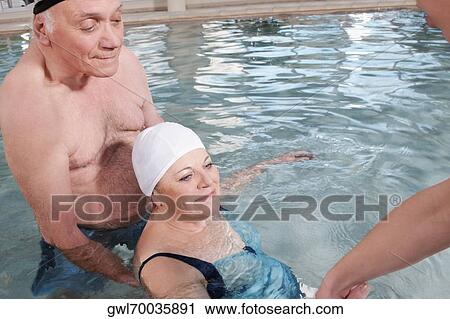 Health worker and a man assisting a woman in a swimming pool View Large Photo Image Stock Image - Health worker and a man assisting a woman in a swimming pool. Fotosearch