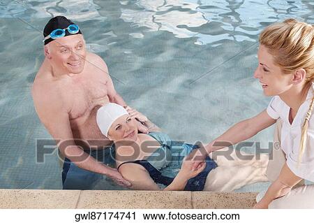 Health worker and a man assisting a woman in a swimming pool View Large Photo Image Stock Image - Health worker and a man assisting a woman in a swimming pool. Fotosearch