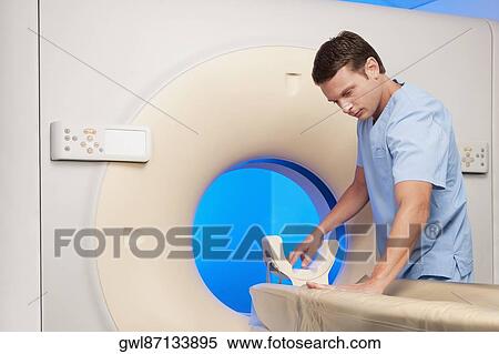 Healthcare worker examining a CAT scan machine View Large Photo Image Stock Photography - Healthcare worker examining a CAT scan machine. Fotosearch