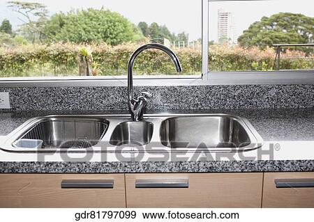 Kitchen sink in front of a glass window View Large Photo Image Stock Photo - Kitchen sink in front of a glass window. Fotosearch