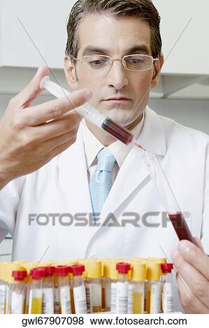 Lab technician filling blood in a test tube from a syringe View Large Photo Image Stock Photo - Lab technician filling blood in a test tube from a syringe. Fotosearch