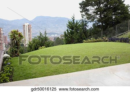 Lawn with buildings and mountains in the background View Large Photo Image Stock Photography - Lawn with buildings and mountains in the background. Fotosearch