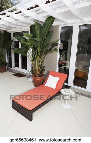 Lounge chair and house plants on the porch of a house View Large Photo Image Stock Image - Lounge chair and house plants on the porch of a house. Fotosearch