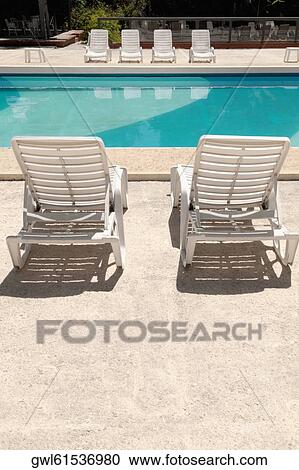 Stock Image - Lounge chairs at the poolside. Fotosearch