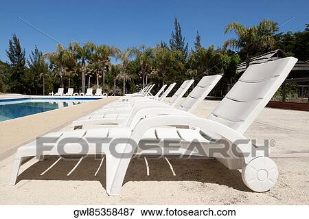 Stock Photo - Lounge chairs at the poolside. Fotosearch