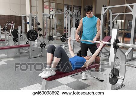 Male instructor assisting a woman in weight training View Large Photo Image Stock Image - Male instructor assisting a woman in weight training. Fotosearch