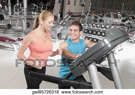 Man assisting a woman on a treadmill View Large Photo Image Stock Photo - Man assisting a woman on a treadmill. Fotosearch