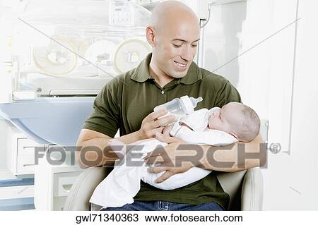 Man carrying his newborn baby View Large Photo Image Stock Image - Man carrying his newborn baby. Fotosearch