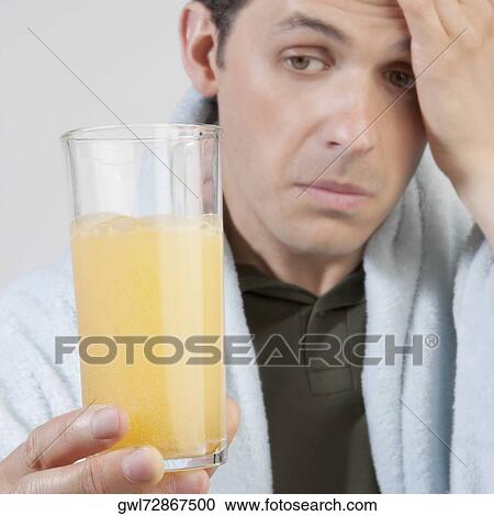 Stock Image - Man drinking orange juice. Fotosearch